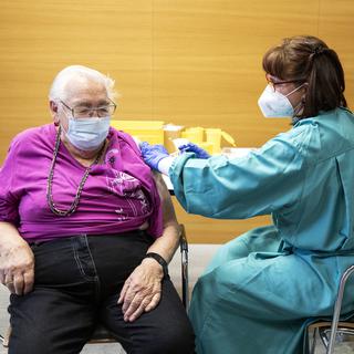 Une patiente âgée reçoit une injection du vaccin contre le Covid-19, le 29 décembre 2020. [Keystone - Alexandra Wey]