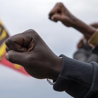 Des milliers de manifestant.e.s le poing levé participent au mouvement antiraciste "Black Lives Matter" contre les violences policières à Genève. [Keystone - Salvatore Di Nolfi]