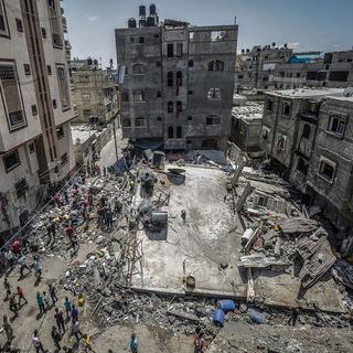 Des Palestiens inspectant une maison détruite par des frappes aériennes israéliennes dans le nord de Gaza, le 20 mai 2021. [EPA/Keystone - Haitham Imad]