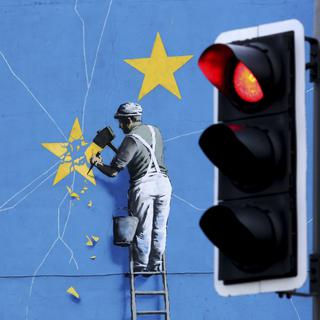 La fresque de Banksy sur le Brexit représentant un homme détruisant le drapeau de l'UE. [KEYSTONE - Gareth Fuller / AP]