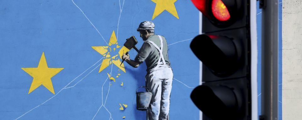 La fresque de Banksy sur le Brexit représentant un homme détruisant le drapeau de l'UE. [KEYSTONE - Gareth Fuller / AP]