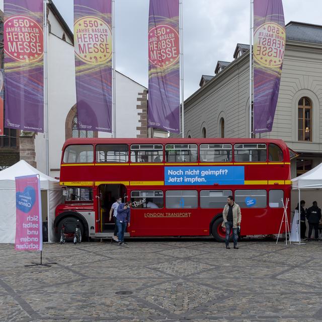 Le bus de vaccination se tient prêt sur la Barfuesserplatz à Bâle, lundi 20 septembre 2021. À partir du 13 septembre 2021, un bus de vaccination circulera pendant quatre semaines dans le canton de Bâle-Ville, où le public pourra se faire vacciner spontanément contre le coronavirus sans avoir à prendre rendez-vous au préalable. [KEYSTONE - Georgios Kefalas]