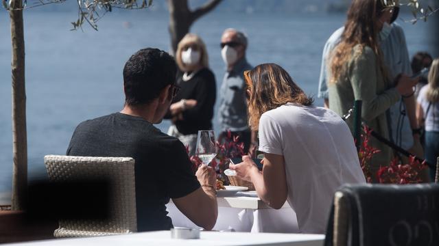 Un couple attablé à la terrasse d'un hôtel à Ascona (TI), pendant le week-end de Pâques, le 2 avril 2021. [Keystone - Alessandro Crinari]