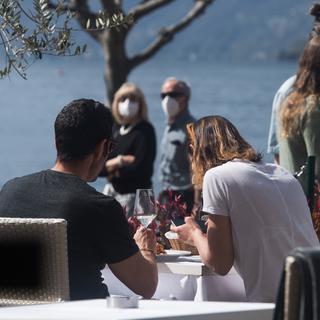 Un couple attablé à la terrasse d'un hôtel à Ascona (TI), pendant le week-end de Pâques, le 2 avril 2021. [Keystone - Alessandro Crinari]