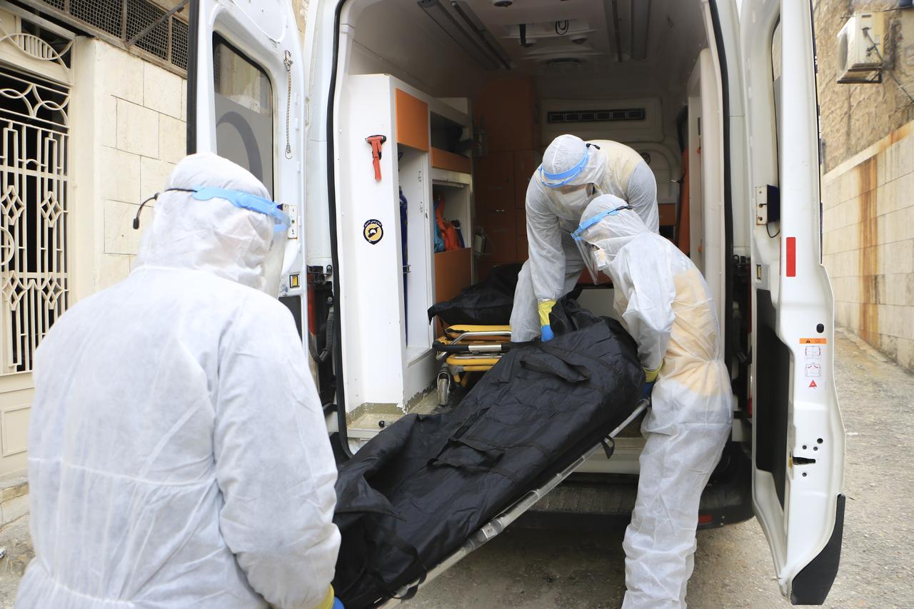 Trois membres des Casque blanc réceptionnent deux corps à l'hôpital al-Ziraa d'Idlib avant de les amener au cimetière. (26 janvier 2021) [RTS - Abd Almajed Alkarh]