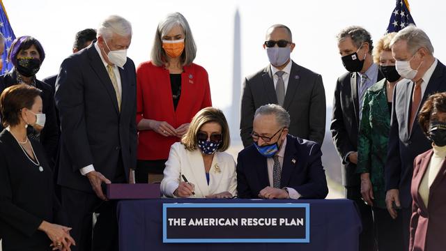 La présidente de la Chambre, Nancy Pelosi, signe le plan de relance après son approbation, 10.03.2021. [AP/Keystone - Alex Brandon]