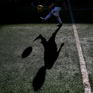 Un enfant s'entraîne au football. [EPA/Keystone - Wu Hong]