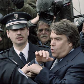 Bernard Tapie sort du tribunal de Valenciennes en 1995, escorté par la police. [AFP - Thomas Coex]