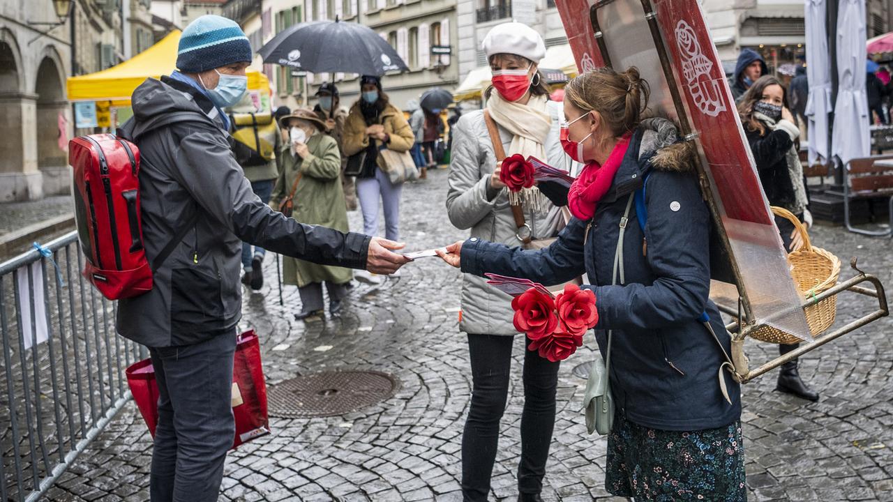 La municipale socialiste Florence Germond et la candidate Emilie Moeschler en campagne sur le marché de la Palud à Lausanne, le 12 décembre 2020. [Keystone - Jean-Christophe Bott]