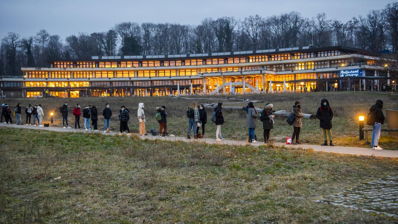 Des étudiants attendent d'entrer dans la bibliothèque de l'université de Lausanne. [Keystone - Jean-Christophe Bott]