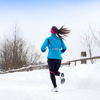 Une femme fait son jogging dans la neige. [Depositphotos - halfpoint]