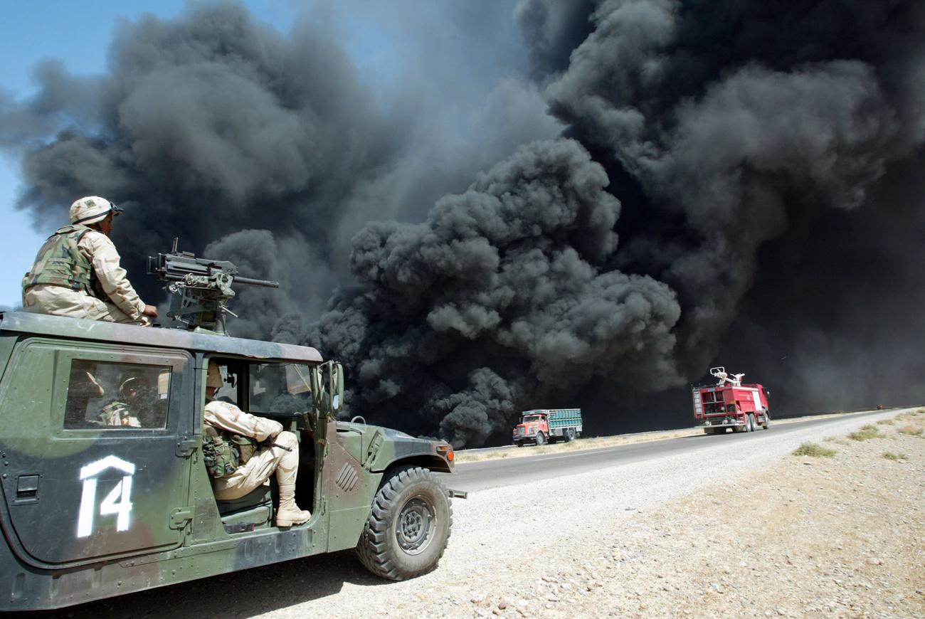 Des soldats américains devant un pipeline en feu en Irak, le 17 août 2003 [Keystone - Murad Sezer]
