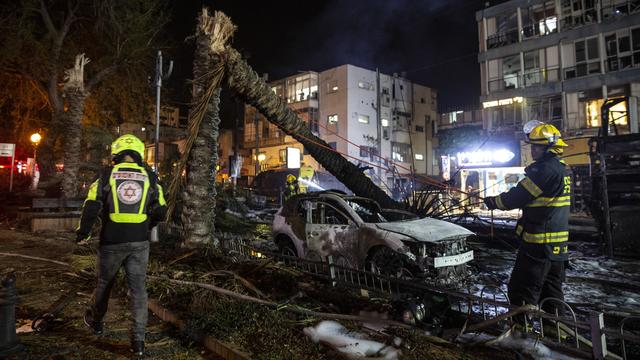 Des pompiers israéliens à l'oeuvre sur le site d'impact d'une roquette à Tel Aviv, le 11 mai 2021. [Keystone - Heidi Levine]