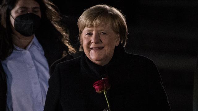 La chancelière allemande Angela Merkel tient une rose rouge alors qu'elle quitte le ministère de la Défense lors de sa cérémonie d'adieu à Berlin, le 2 décembre 2021. [AFP - Stefanie Loos]