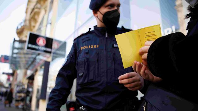 Un policier autrichien effectue un contrôle à l'entrée d'un magasin à Vienne le 16 novembre 2021. [Reuters - Lisi Niesner]