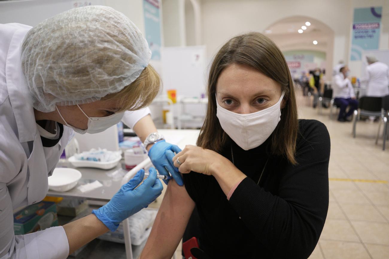 Une personne reçoit le vaccin russe Sputnik V dans un centre de vaccination de Moscou, le 19 novembre 2021. [Keystone/AP photo - Pavel Golovkin]