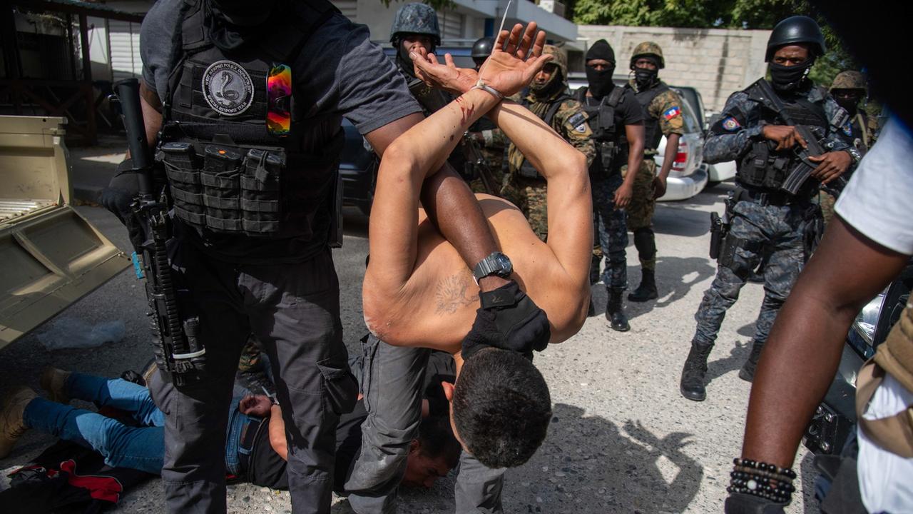Des policiers arrêtent des suspects à Port-au-Prince le 8 juillet 2021, après l'assassinat du président haïtien. [Keystone - EPA/Jean Marc Herve Abelard]