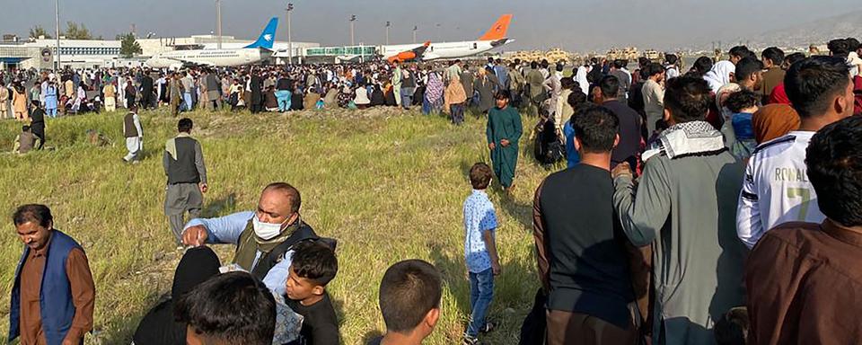 De nombreux Afghans ont gagné l'aéroport de Kaboul, dans l'esoir de pouvoir embarquer à bord d'un avion. [AFP - Shakib Rahmani]