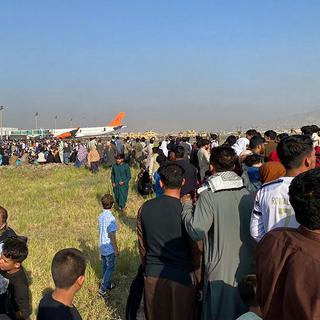 De nombreux Afghans ont gagné l'aéroport de Kaboul, dans l'esoir de pouvoir embarquer à bord d'un avion. [AFP - Shakib Rahmani]