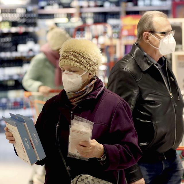 Les clients d'un supermarché de Vienne avec des masques FFP2. [Keystone - AP Photo/Ronald Zak]