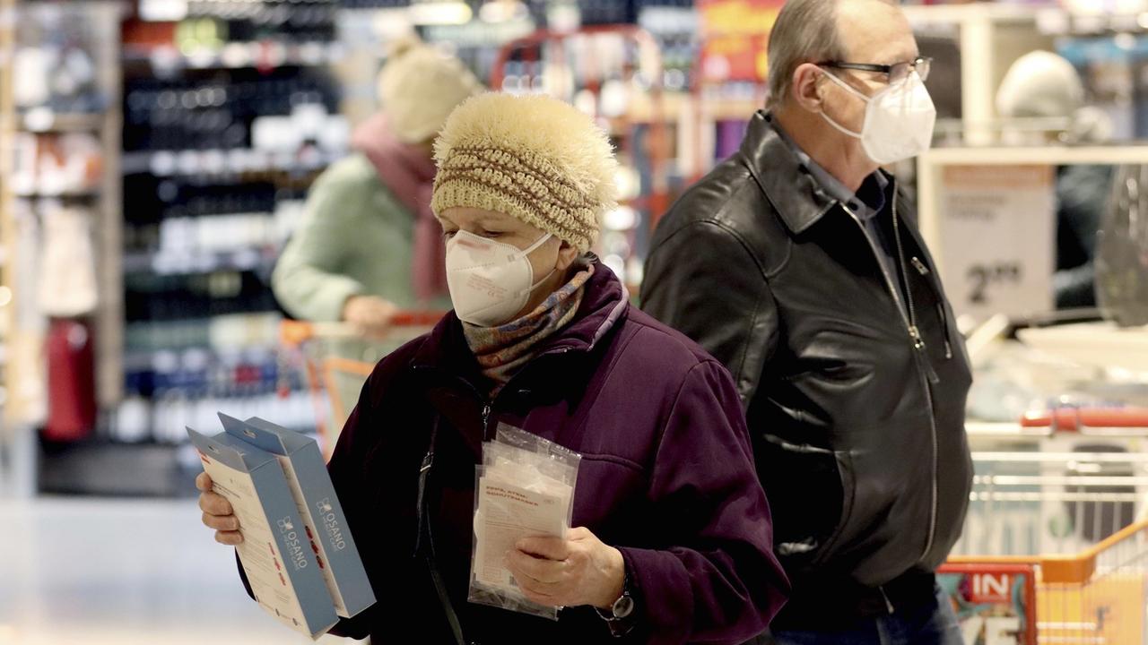 Les clients d'un supermarché de Vienne avec des masques FFP2. [Keystone - AP Photo/Ronald Zak]