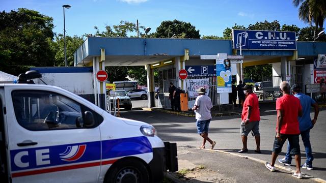 La police est postée devant le Centre Hospitalier de Pointe-à-Pitre où le personnel médical tient un picket de grève contre les mesures prises pour contrer la contamination au Covid-19. Guadeloupe, le 26 novembre 2021. [AFP - Christophe Archambault]