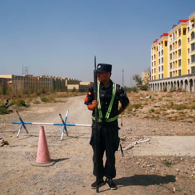 Un policier chinois garde une route près d'un "centre de formation professionnelle" dans le Xinjiang. [Reuters - Thomas Peter]