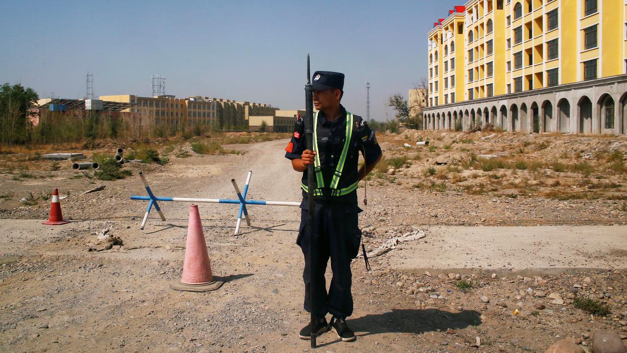 Un policier chinois garde une route près d'un "centre de formation professionnelle" dans le Xinjiang. [Reuters - Thomas Peter]