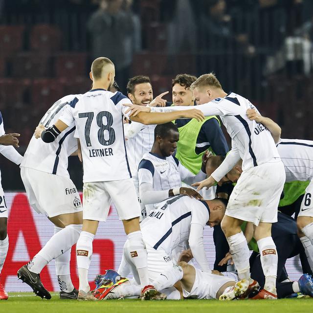 Nikola Boranijasevic du FC Zuerich, au sol, applaudit avec ses coéquipiers après avoir marqué le premier but de son équipe contre le gardien du FC Bâle Heinz Lindner, au centre, lors du match de Super League de football entre le FC Zuerich et le FC Bâle au stade du Letzigrund à Zuerich, samedi 30 octobre 2021. [Keystone - Michael Buholzer]