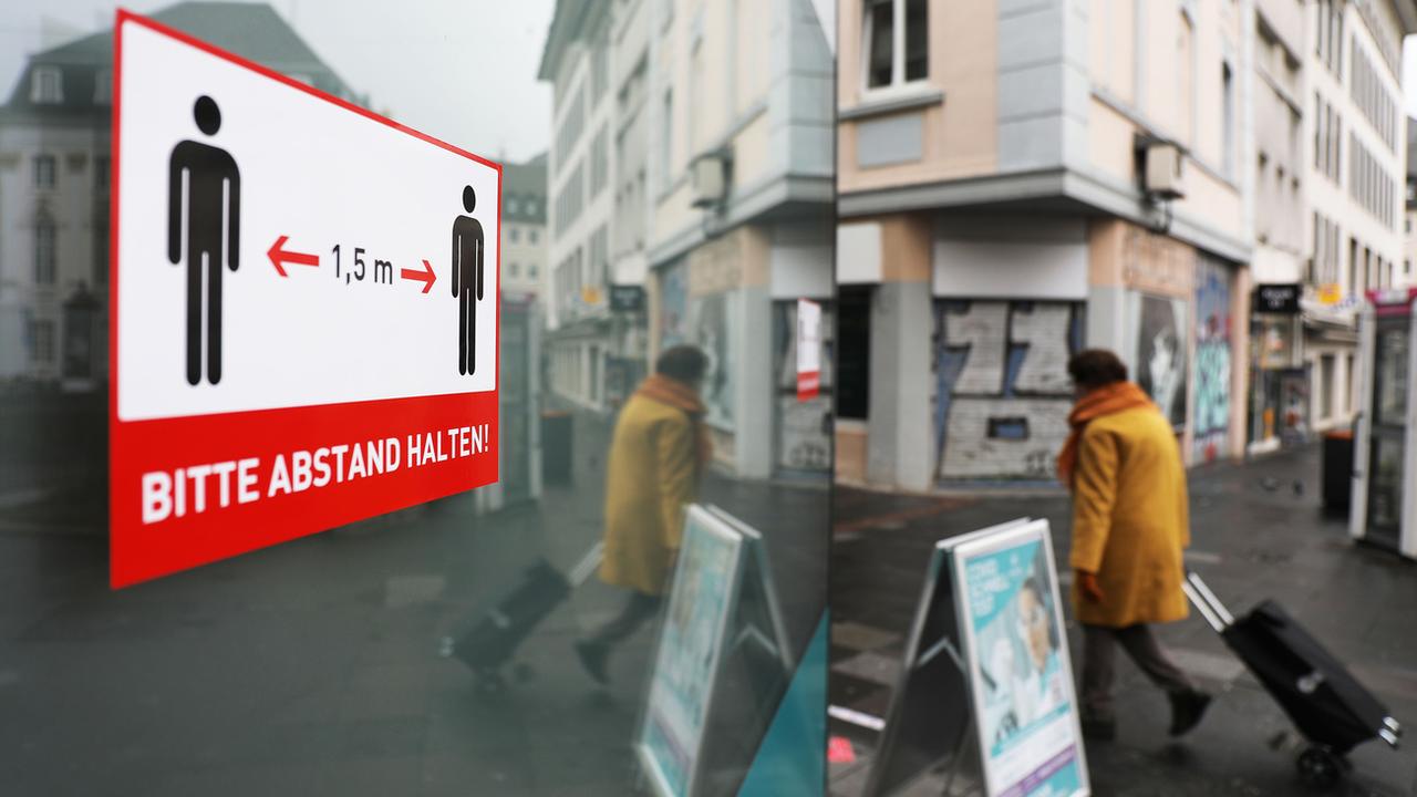 Un panneau priant de respecter les distances à Bonn, en Allemagne. [Keystone - DPA/Oliver Berg]