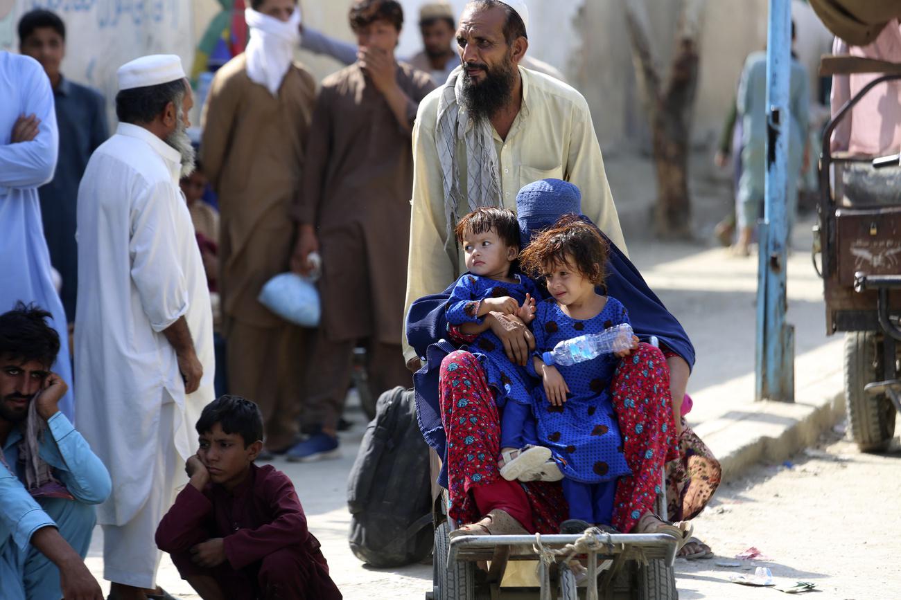 Des personnes réfugiées de nationalité afghane attendent de pouvoir passer la frontière entre leur pays et le Pakistan. Torkham, le 21 août 2021. [Keystone/AP photo - Muhammad Sajjad]