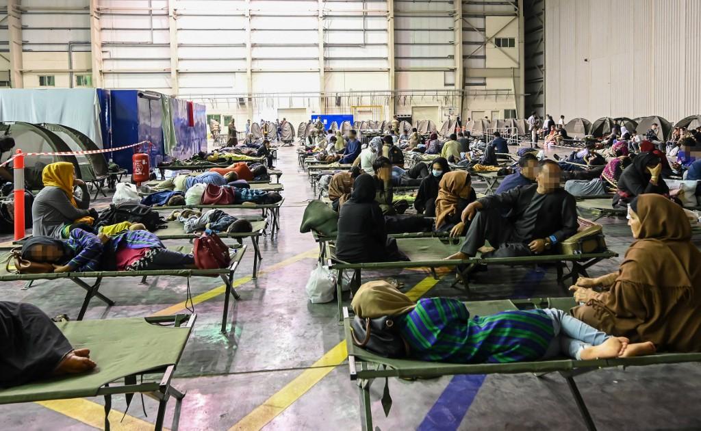 Réfugiées et réfugiés en provenance de Kaboul dans le cadre de l'opération "Apagan" attendent leur évacuation. Base militaire française 104 d'Al Dhafra, Abou Dhabi, le 23 août 2021. [AFP - Bertrand Guay]