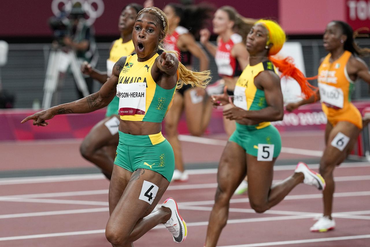 Elaine Thompson-Herah jubile devant ses compatriotes et dauphines. En arrière-plan, Ajla Del Ponte et Mujinga Kambundji, héroïnes de l'athlé suisse. [AP - David J. Phillip]