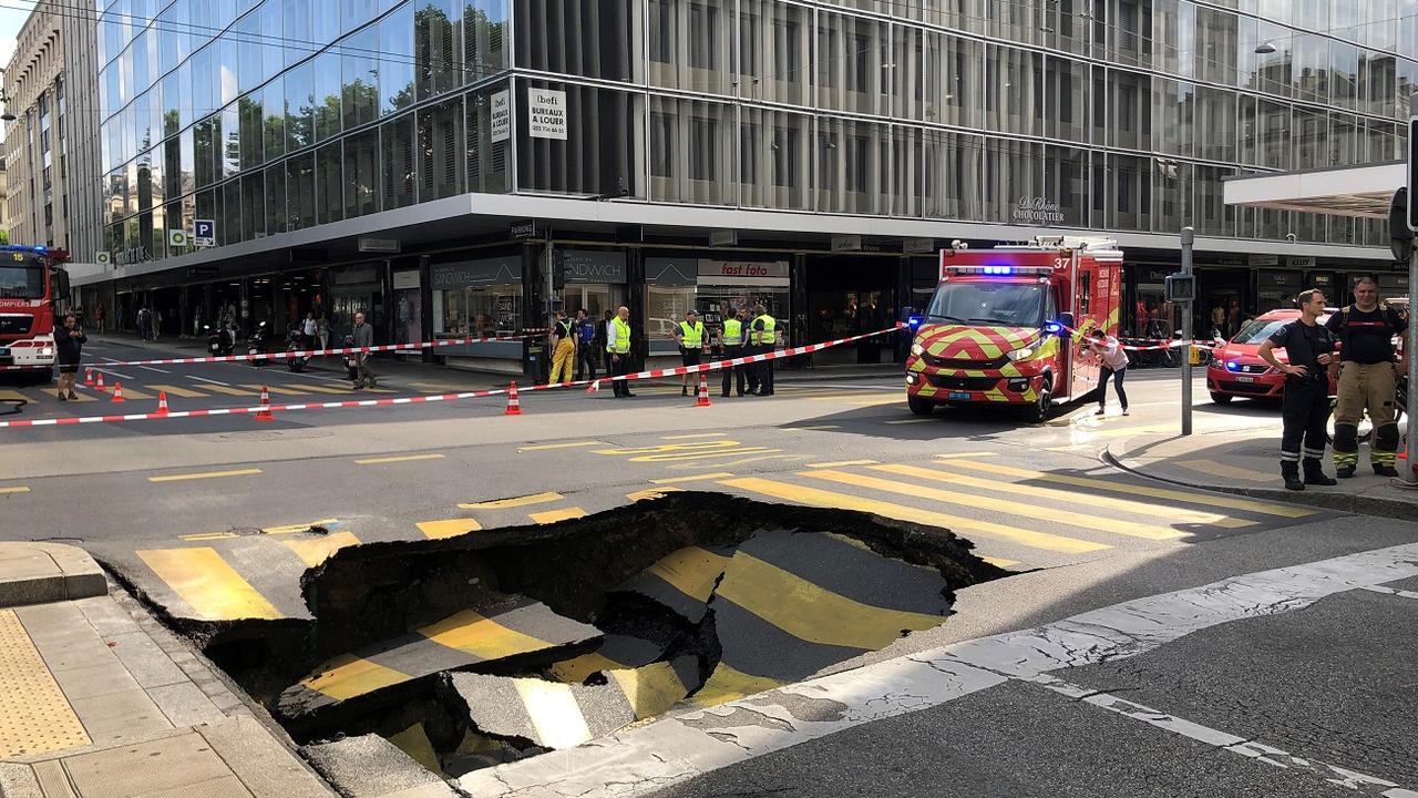 Un trou est subitement apparu sur la chaussée au centre de Genève. [RTS - Julien von Roten]