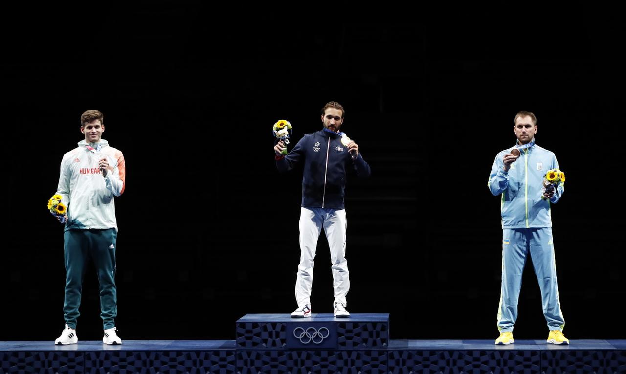 Les épéistes Gergely Siklosi (à gauche, médaillé d'argent),  Romain Cannone (au centre, médaillé d'or) et  Igor Reizlin (à droite, médaillé de bronze) ont enlevé leur masque devant les photographes. [KEYSTONE - KIYOSHI OTA]