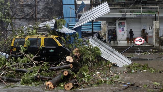 Un arbre est tombé sur un taxi suite à de fortes pluies. Bombay, le 17 mai 2021. [Keystone/AP photo - Rajanish Kakade]