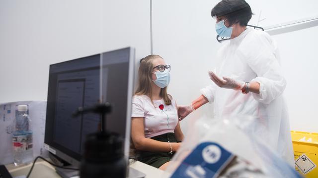 Une jeune fille se fait vacciner contre le Covid au Tessin. [Ti-Press/Keystone - Alessandro Crinari]