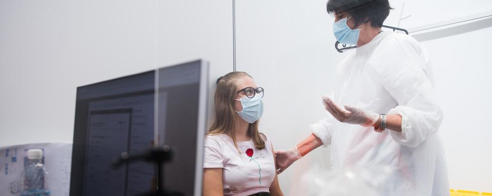 Une jeune fille se fait vacciner contre le Covid au Tessin. [Ti-Press/Keystone - Alessandro Crinari]