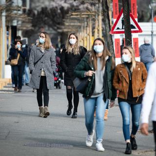 Des personnes portent un masque dans les rues de Lugano. [Keystone - Ti-Press/Elia Bianchi]