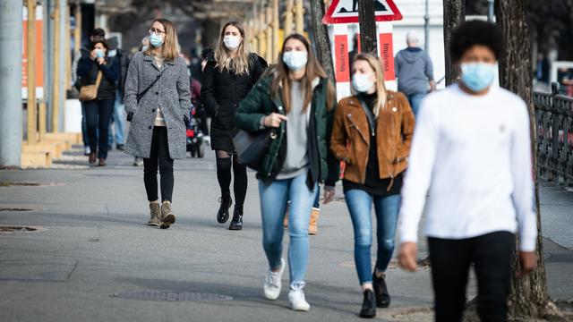 Des personnes portent un masque dans les rues de Lugano. [Keystone - Ti-Press/Elia Bianchi]