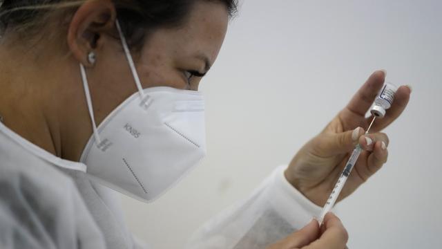 Une infirmière prépare un vaccin à Lisbonne. [Keystone - AP Photo/Armando Franca]