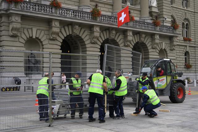 Les équipes logistiques de la police bernoise étaient à pied d'oeuvre jeudi pour protéger la Coupole fédérale d'une éventuelle manifestation non-autorisée. [Keystone - Anthony Anex]