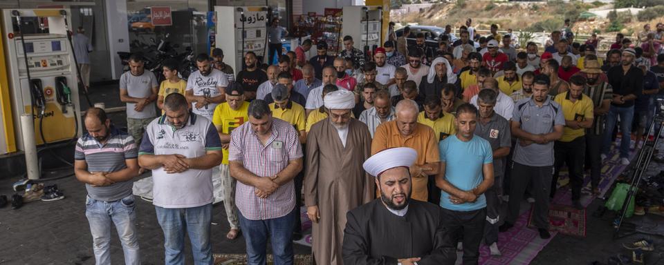 Des fidèles musulmans photographiés à une station service au sud de Beyrouth, le 3 septembre 2021. [Keystone - Hassan Ammar]