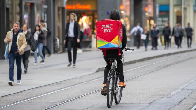 Un coursier travaillant pour Just Eat dans les rues de Genève. [Keystone - Salvatore Di Nolfi]