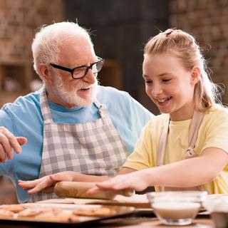 Un homme âgé et une adolescente cuisine ensemble. [Depositphotos - TarasMalyarevich]