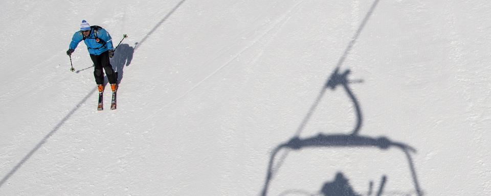 Des personnes profitent du soleil et de la neige pour faire du ski sur les pistes du domaine skiable ce vendredi 6 avril 2018 a Crans-Montana. [Keystone - Jean-Christophe Bott]