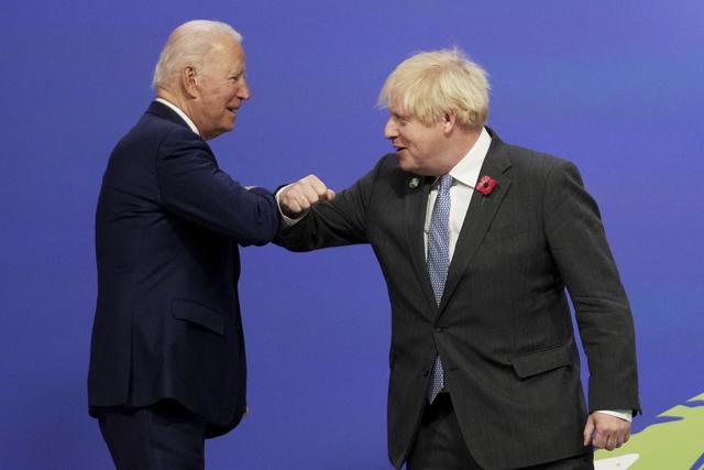 Le salut de Boris Johnson à Joe Biden en ouverture de la COP26 à Glasgow. [Keystone - Christopher Furlong/Pool via AP]