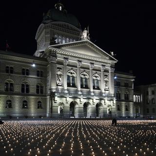 La Place fédérale à Berne couverte de bougies pour commémorer les personnes décédées de la Covid-19 (Coronavirus) en Févriver 2021. [Keystone - Peter Schneider]