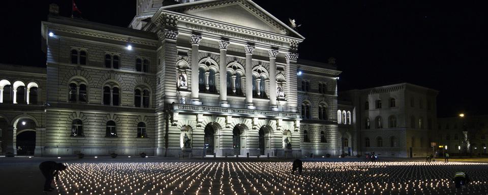 La Place fédérale à Berne couverte de bougies pour commémorer les personnes décédées de la Covid-19 (Coronavirus) en Févriver 2021. [Keystone - Peter Schneider]