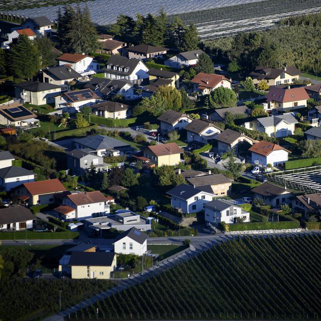 Des maisons dans un quartier d'habitation en limite de zone agricole à Ardon. [Keystone - Laurent Gillieron]